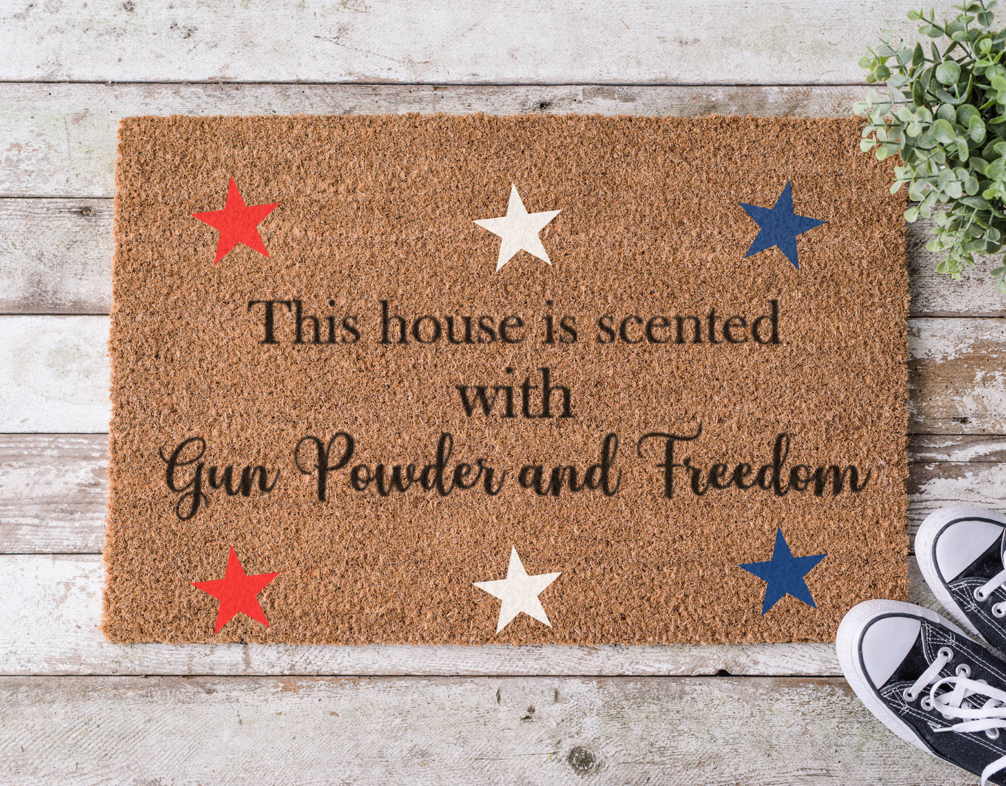 Coir doormat with bold lettering that reads ‘House is Scented with Gun Powder and Freedom,’ hand-painted in a rustic, patriotic style.