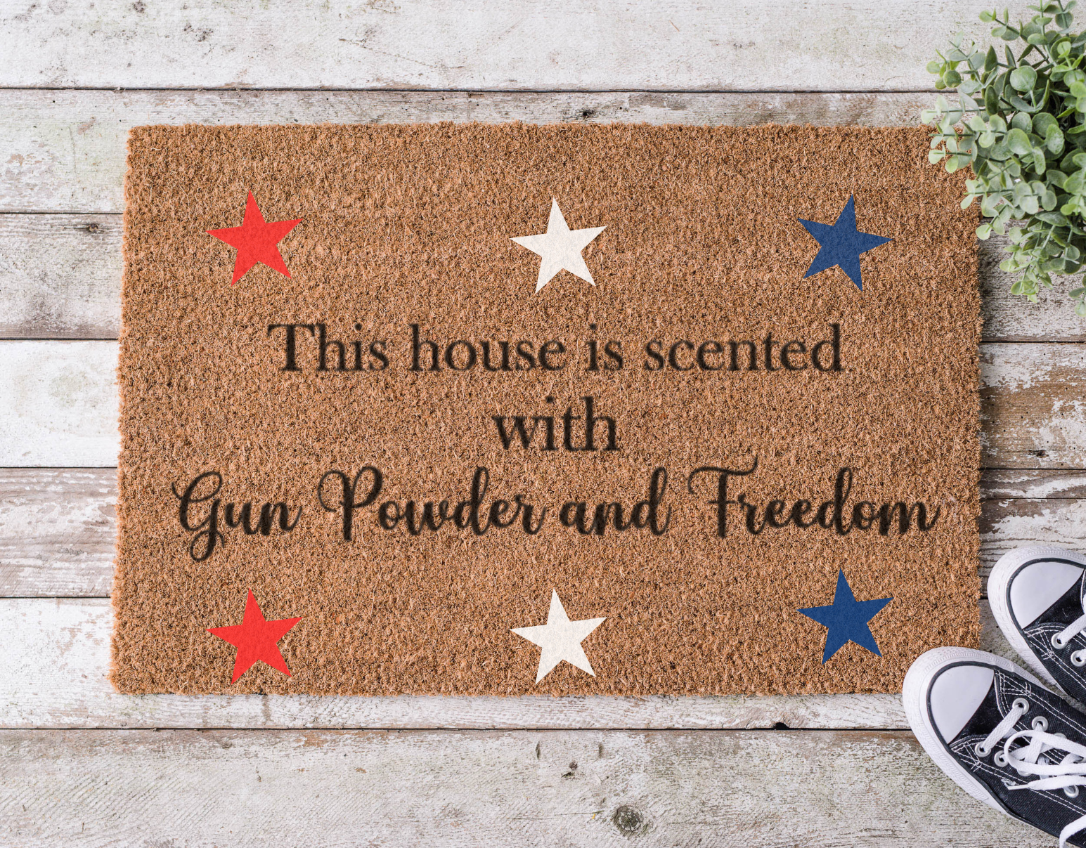 Coir doormat with bold lettering that reads ‘House is Scented with Gun Powder and Freedom,’ hand-painted in a rustic, patriotic style.