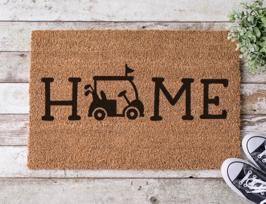 Coir doormat with the word ‘Home’ featuring a golf cart icon as the letter O, hand-painted in a sporty golf-themed design