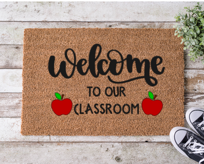 Coir doormat that says ‘Welcome to Our Classroom,’ hand-painted in bold, playful lettering for teachers and school entrances