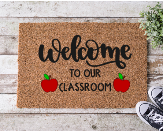 Coir doormat that says ‘Welcome to Our Classroom,’ hand-painted in bold, playful lettering for teachers and school entrances