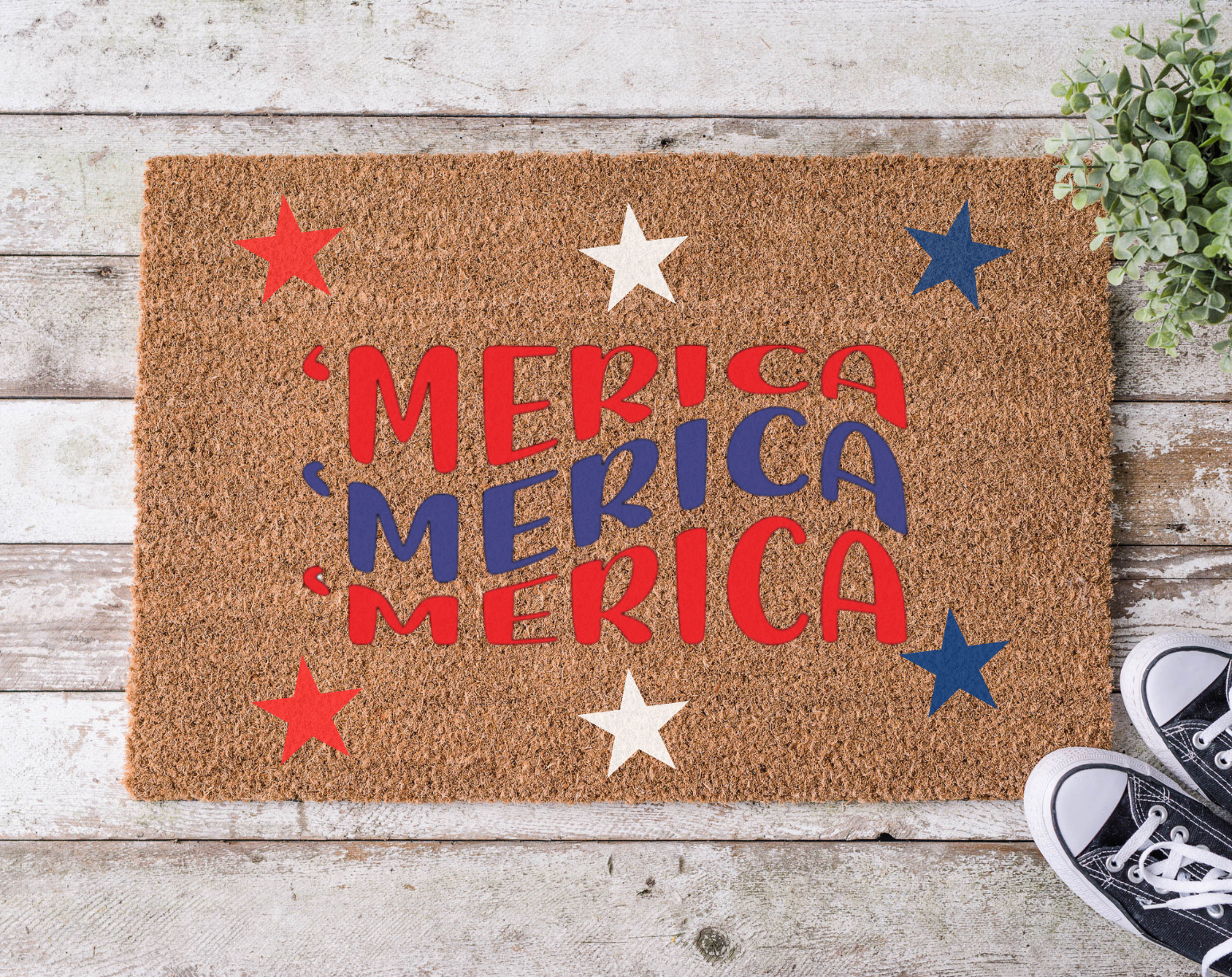 A rectangular doormat with a brown background and the word 'MERICA' written in bold, red and blue letters, surrounded by decorative stars in red and blue colors.