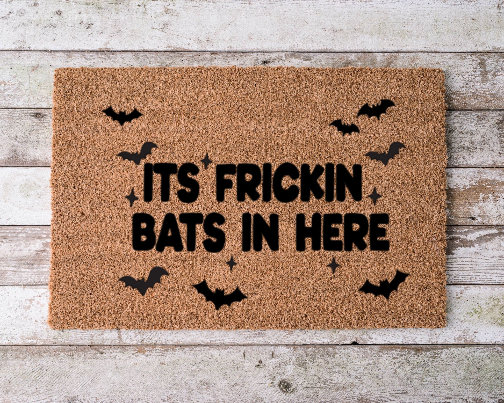 Doormat with the phrase “It’s Frickin Bats in Here” and hand-painted flying bat illustrations – funny Halloween porch decor.