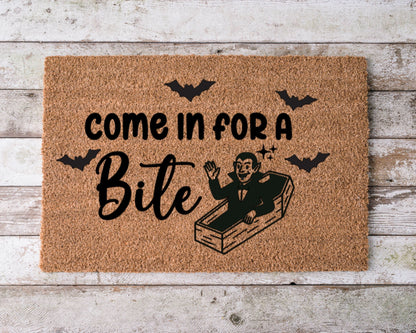 Halloween doormat that says “Come in for a bite” with a smiling cartoon vampire illustration – spooky fall porch decor.