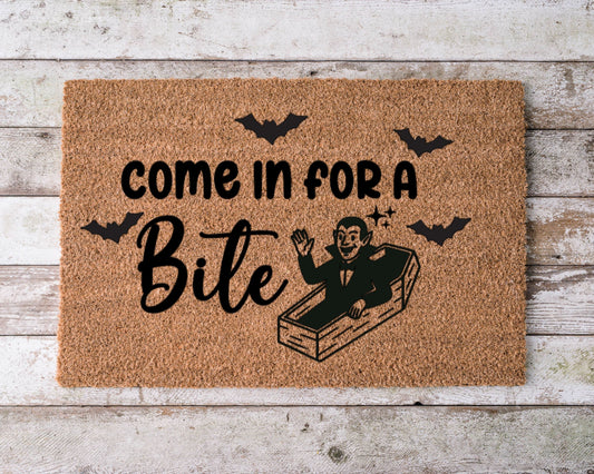 Halloween doormat that says “Come in for a bite” with a smiling cartoon vampire illustration – spooky fall porch decor.