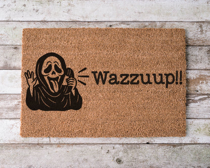 Halloween doormat with the phrase “Wazzzup” and a hand-painted image of Ghostface from Scream – horror movie-themed spooky porch decor.