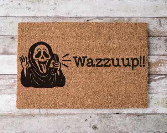 Halloween doormat with the phrase “Wazzzup” and a hand-painted image of Ghostface from Scream – horror movie-themed spooky porch decor.
